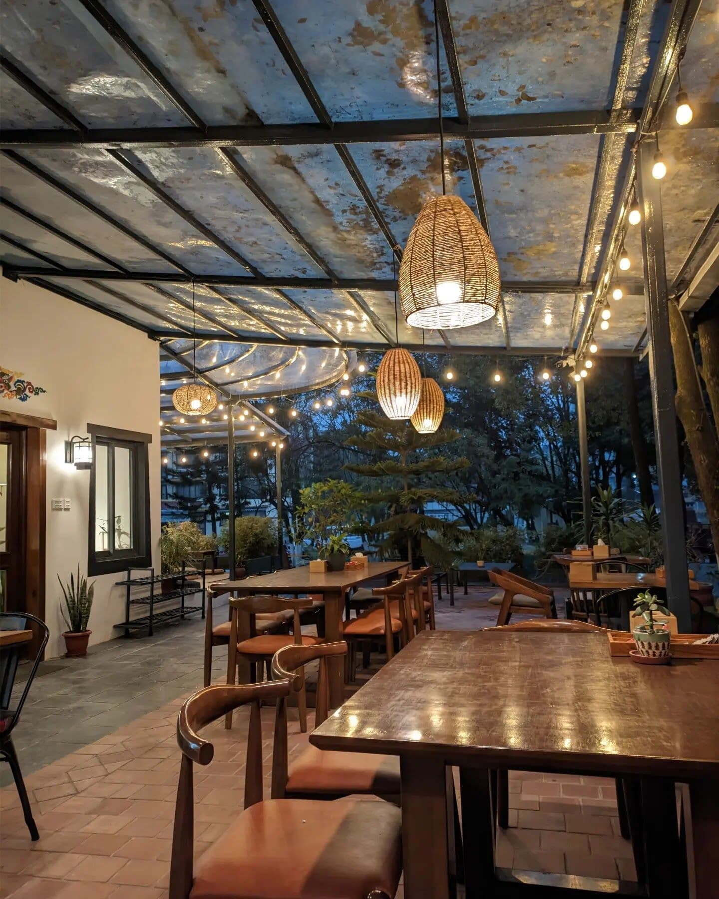 The terrace in the evening under woven lanterns and string lights